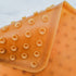 Close-up of an orange textured object with a light blue background