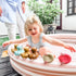 Child playing with rubber ducks in a small pool outdoors
