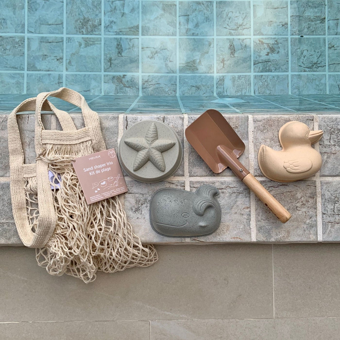 Decorative items including a net bag, starfish, whale, and duck-shaped objects against a tiled wall.