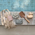 Decorative items including a net bag, starfish, whale, and duck-shaped objects against a tiled wall.