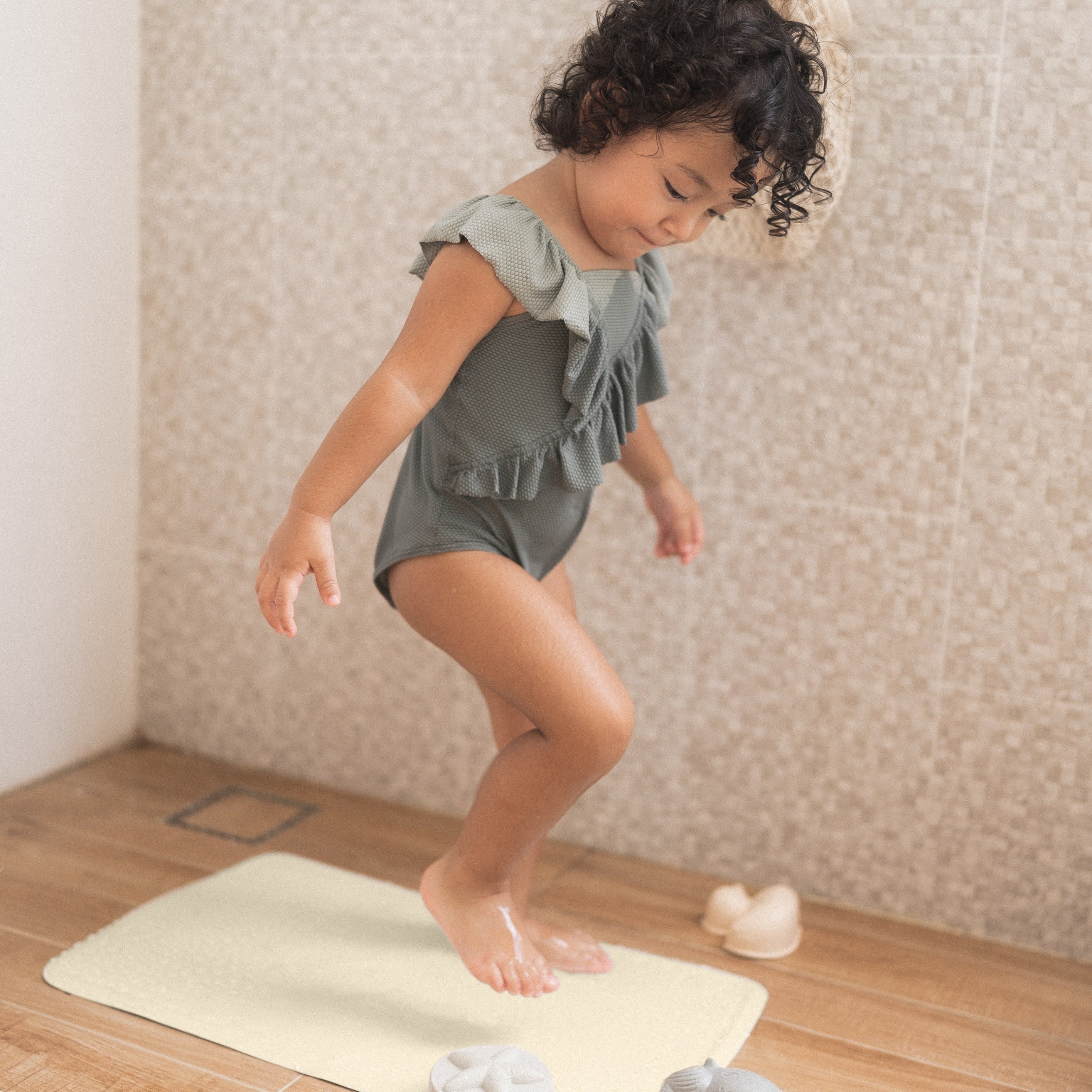 Toddler playing on Honeycomb anti slip baby bath mat, ensuring safety during bath time.