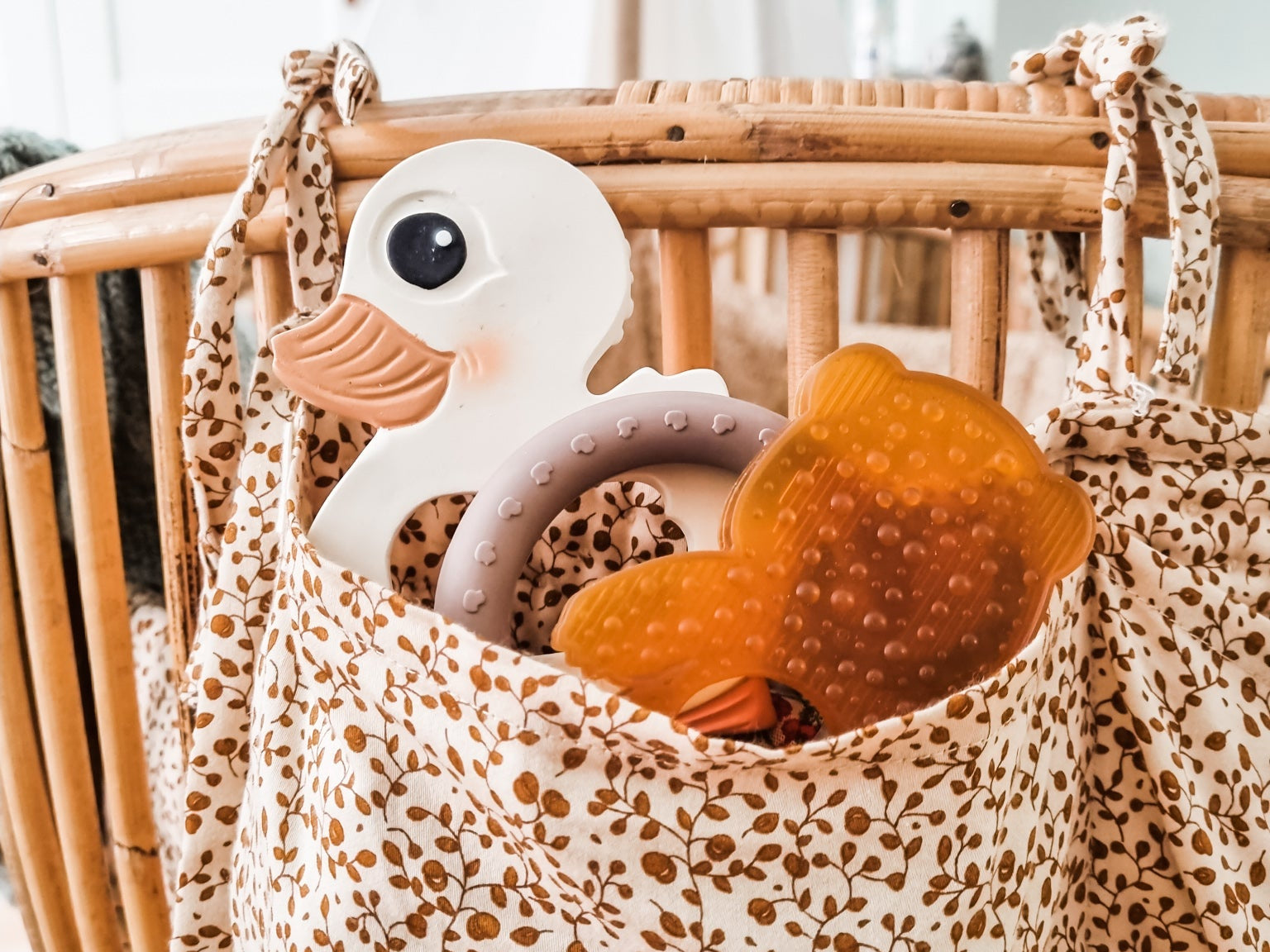 Leopard print bag with baby toys inside, placed on a wooden surface.